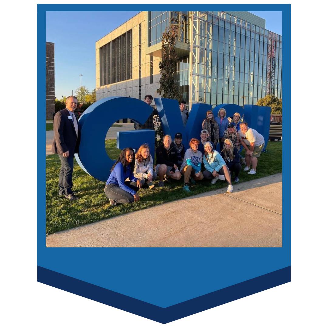 Students in front of GVSU letters
